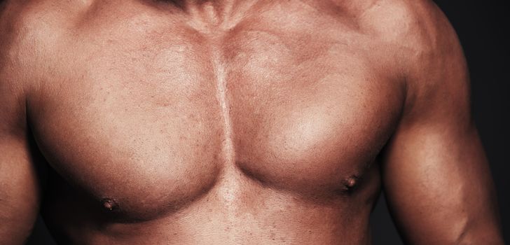 Close-up view on a muscular body. Topless man