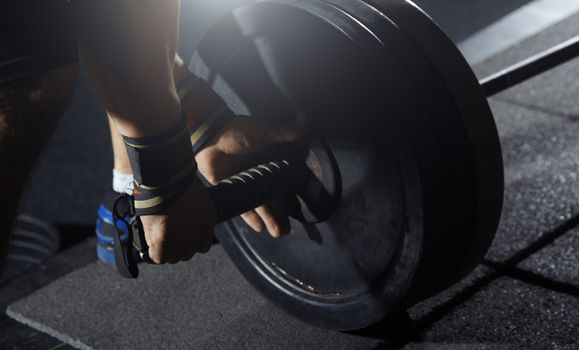 Weightlifter preparing barbell at fitness club