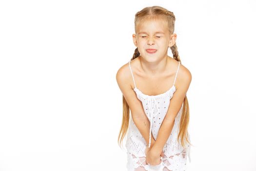 Funny little girl with a charming smile in a white dress 