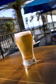 Ice cold beer on a bar table at an outdoor restaurant