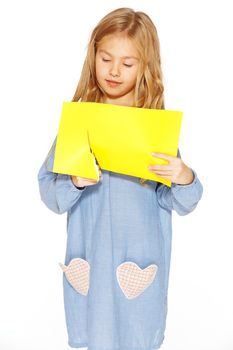 Little cute girl making handmade yellow hearts