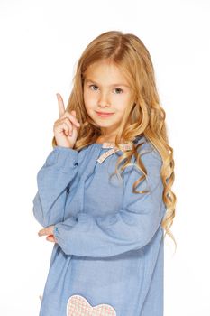 Little girl posing for the camera in blue dress with blond curls