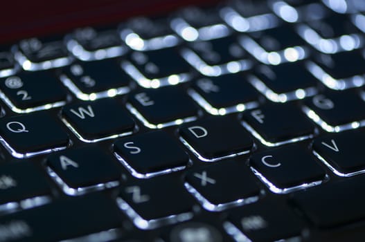 Illuminated keyboard. Focus on WASD keys. Shallow depth of field