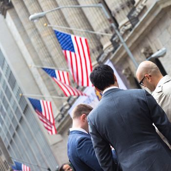 New York City, United States of America - March 26: Businessmen talking on Wall street in front of New York Stock Exchange on March 26, 2015.