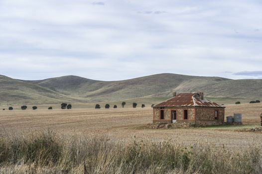 Abandoned farm house on a rural farm built from stone and iron