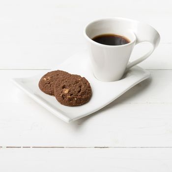 coffee cup with cookie on white wood background