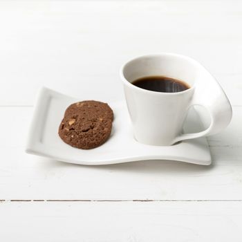 coffee cup with cookie on white wood background