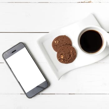 coffee cup with cookie and phone on white wood background