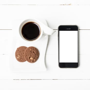 coffee cup with cookie and phone on white wood background