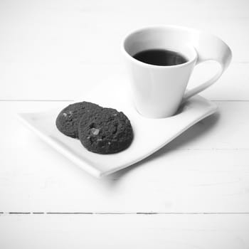 coffee cup with cookie on white wood background black and white color