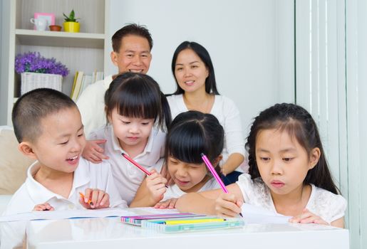 asian family doing school homework at living room