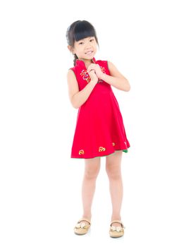 Chinese young girl in traditional Chinese cheongsam blessing, isolated on white background