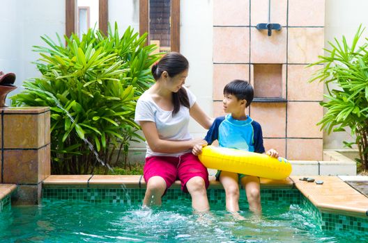 Happy chinese Asian Family Playing in the pool