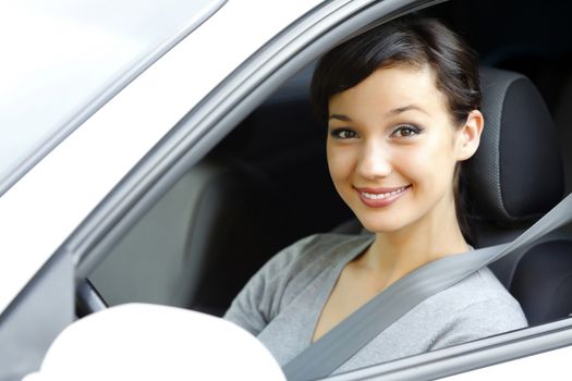 Cute asian female driver in white car smiling to you.