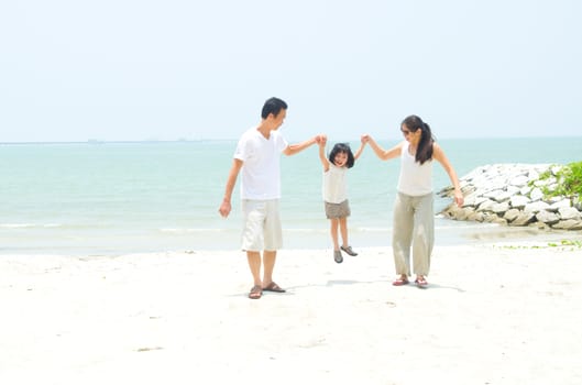 Happy family having fun at beach during summer day