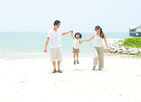 Happy family having fun at beach during summer day