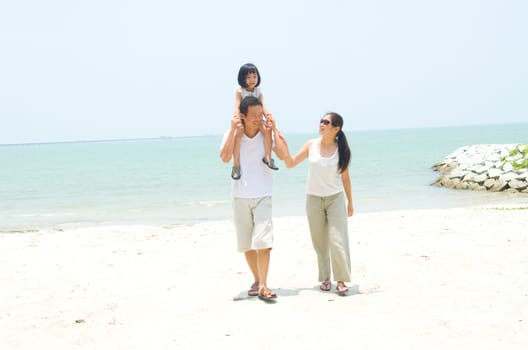 Happy Asian family at the beach