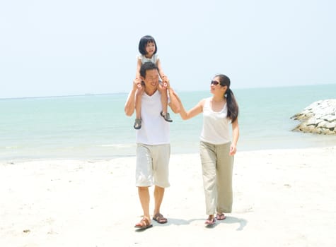 Happy Asian family at the beach