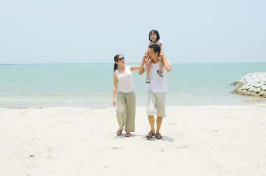 Happy Asian family at the beach