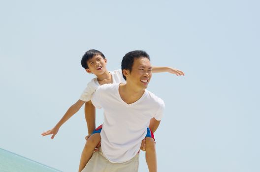 Happy father holding her son on the beach

