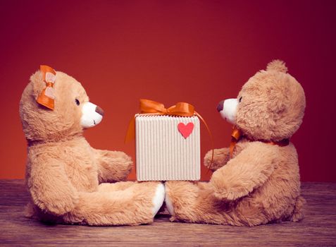 Valentines Day. Love. Couple Teddy Bears loving on date. Handmade red bow, gift box.Vintage retro romantic style. Unusual creative greeting card, red holiday background. Family, wedding and friendship