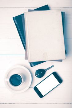 coffee cup with phone,car key and stack of book on white wood table vintage style