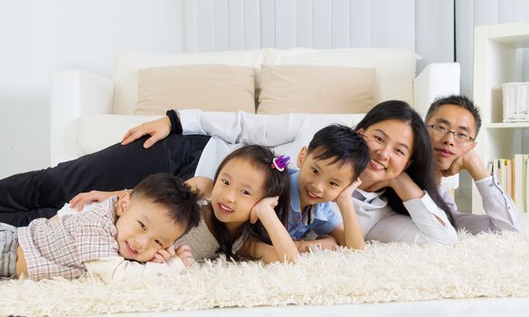 Asian family lying on the floor and smiling