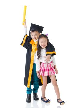 Asian school kid graduate in graduation gown and cap. Taking photo with sister and brother.