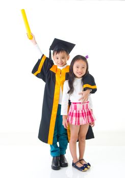 Asian school kid graduate in graduation gown and cap. Taking photo with sister and brother.