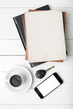 coffee cup with phone,car key and stack of book on white wood table
