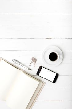 coffee cup with phone, key and open notebook on white wood table