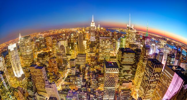 New York City. Manhattan downtown skyline with illuminated Empire State Building and skyscrapers at dusk seen from observation deck. Panoramic fish eye view.