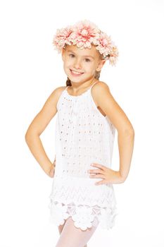 Little girl posing for the camera in white dress with wreath