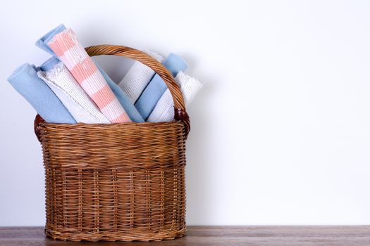 Assorted Clean Rolled School Mats in a Basket Against White Wall with Copy Space