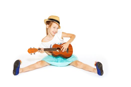 A beautiful little girl with a charming smile with a guitar