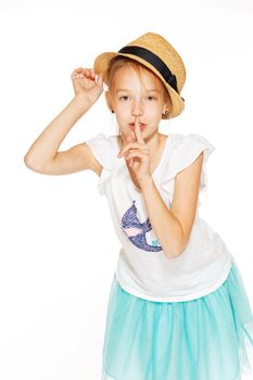 Little girl posing for the camera in a brown hat