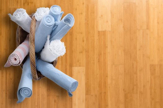 High Angle View of Clean Rolled Mats in a Basket Placed on a Wooden Floor, Emphasizing Ready for Pick up and Start Working.