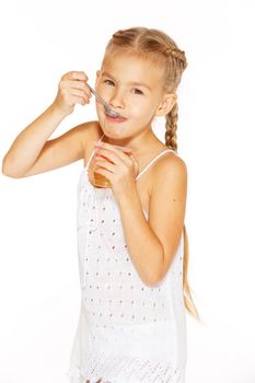 Beautiful little girl with pigtails eating jelly