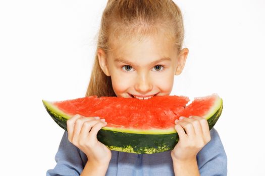 Cute girl in a blue dress eating red juicy watermelon