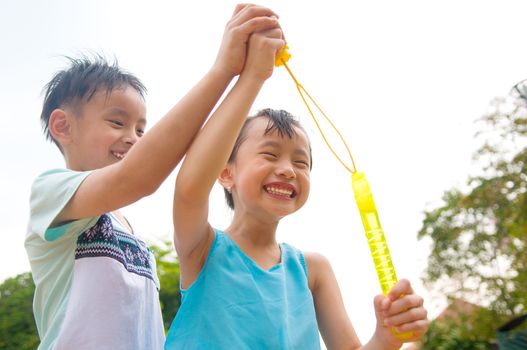 Asian kids blowing bubbles outdoor