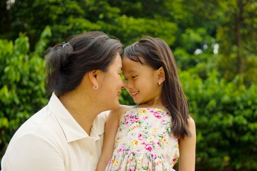 Outdoor portrait of asian mother and her lovely daughter