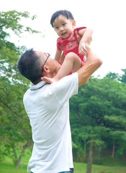 Asian father playing with baby boy