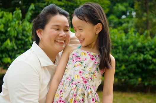 Outdoor portrait of asian mother and her lovely daughter