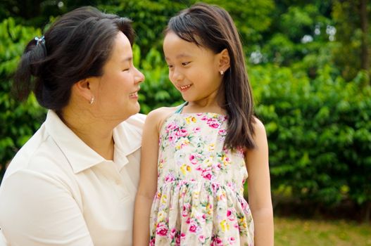 Outdoor portrait of asian mother and her lovely daughter