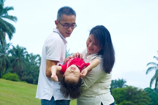 Asian parent having fun with their baby boy