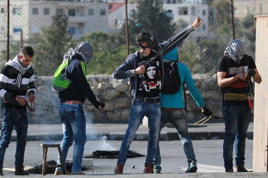 WEST BANK, Bethlehem: A Palestinian protester uses slingshot to throw stones towards Israeli security forces during clashes in the West Bank town of Bethlehem following a funeral ceremony at the nearby Aida refugee camp on January 13, 2016. A Palestinian man identified as Srur Ahmad Abu Srur, 21, was buried at Aida refugee camp a day after he was allegedly shot in the chest by Israeli forces in Beit Jala, a Palestinian health ministry statement said. 