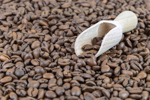 Wooden shovel on a background made of coffee beans