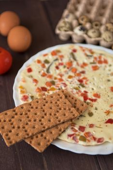 baked omelette with different eggs and vegetables with rye small load of bread