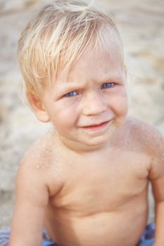 Portrait of a baby with a naked torso on the beach