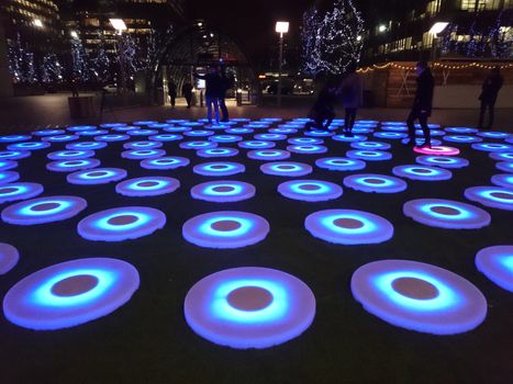 UK, London: The Pool, one of 18 installations at the Canary Wharf Winter Lights festival, lights up London on January 11, 2016 as the festival opens. This exhibit includes 106 touchpads that light up when stepped on. The festival features an intercontinental collection of sculptures, on display in areas like at Crossrail Place, Cabot Square, and Jubilee Park through January 22.